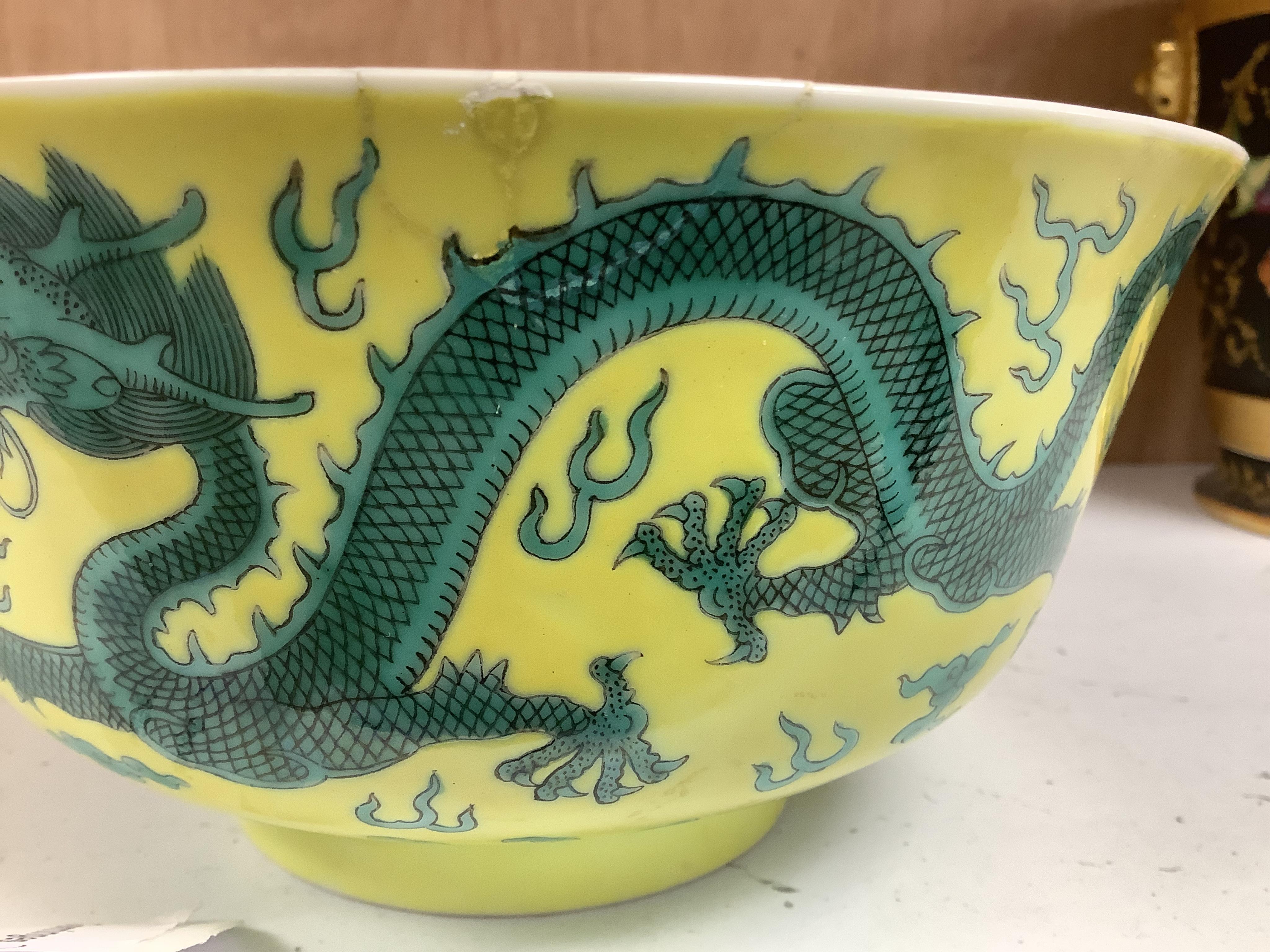 A Chinese yellow ground 'dragon' bowl, probably late Qing dynasty, and a similar floral cup, bowl 9cm high, 18.5cm diameter. Condition - bowl has a large section restored